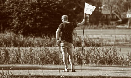 Man with flagstick waiting for slow player